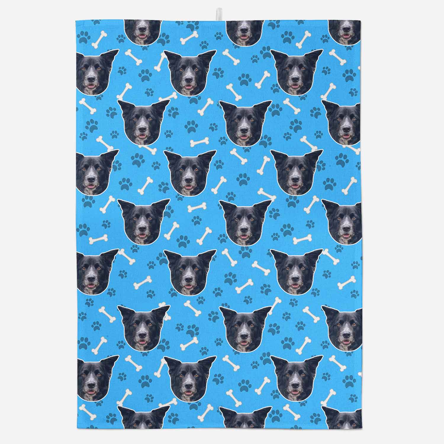 Patterned fabric with black dog faces, bones, and paw prints on a blue background