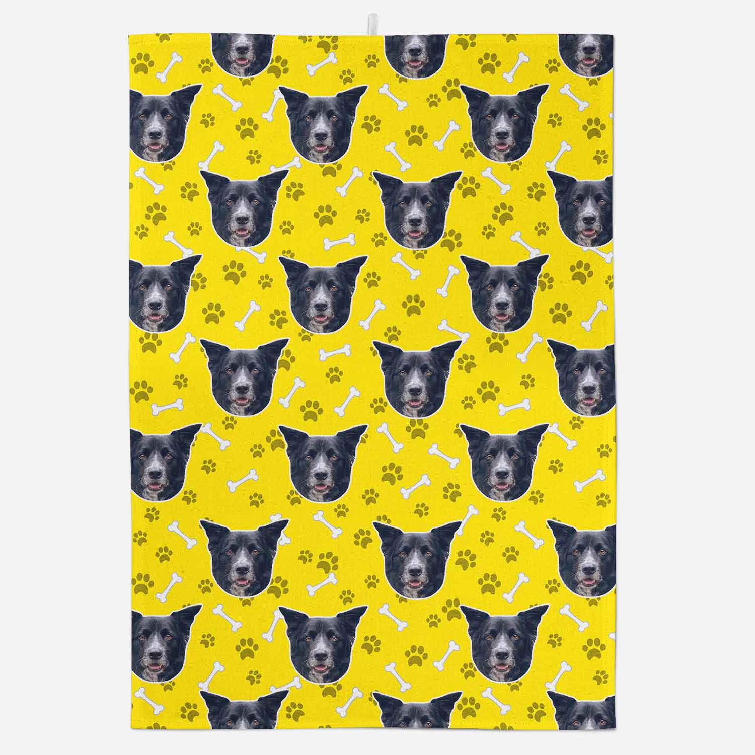 Towel with dog faces and paw prints on a yellow background